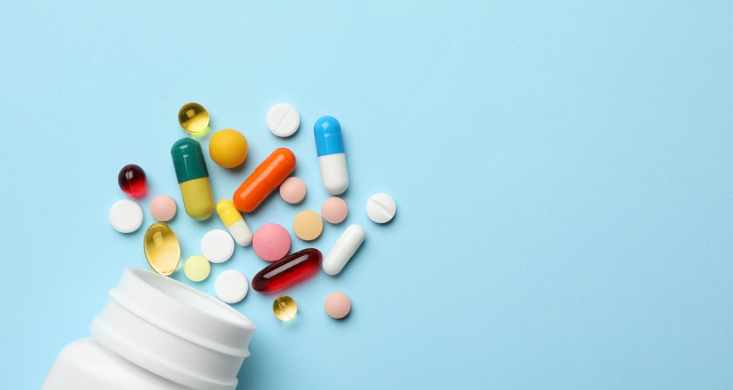 Pharmacy pills spilled on blue background