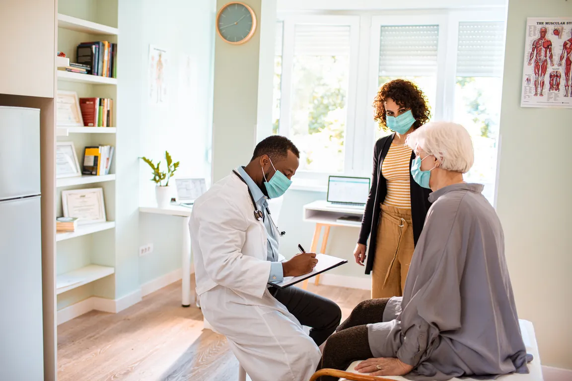Clinician meets with older adult patient and caregiver
