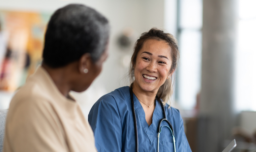 Clinician smiling and talking with a patient while holding a tablet_840x500.png