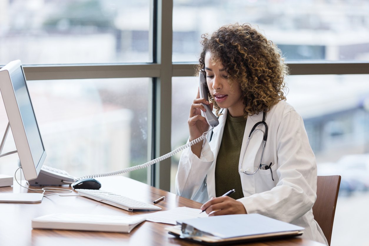 Clinician talking to colleague on phone about a shared patient