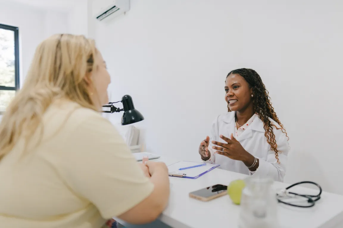 Clinician talking to female patient during an appointment in clinic