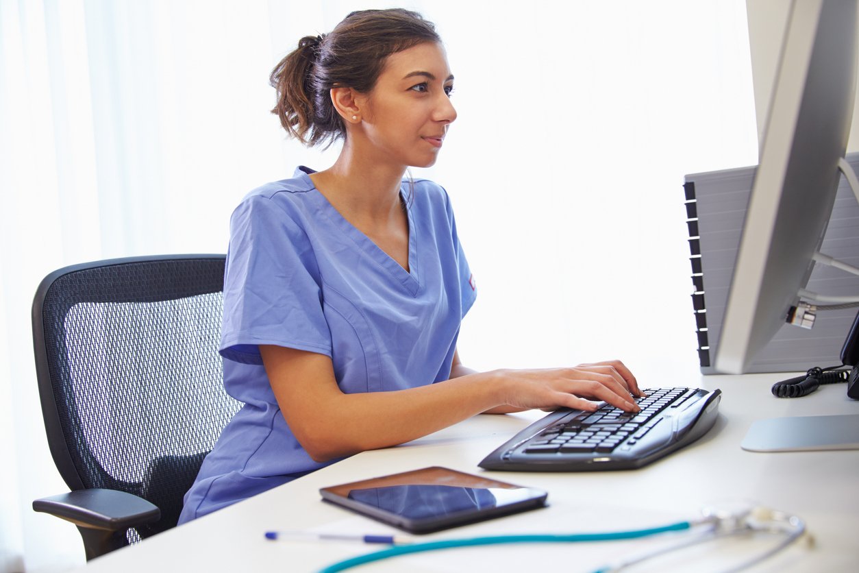 Clinician working on a computer to measure productivity