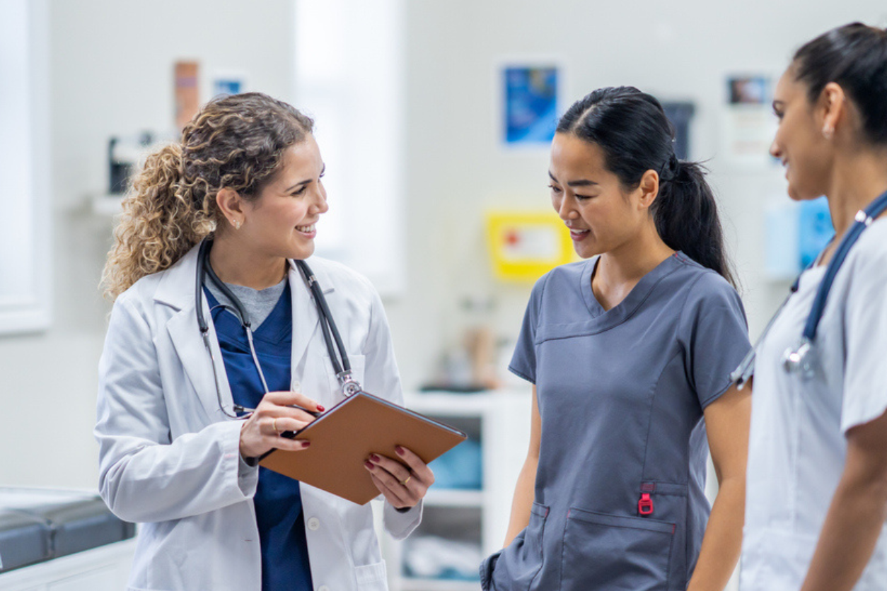 Doctor talking to a nurse and others in the hallway