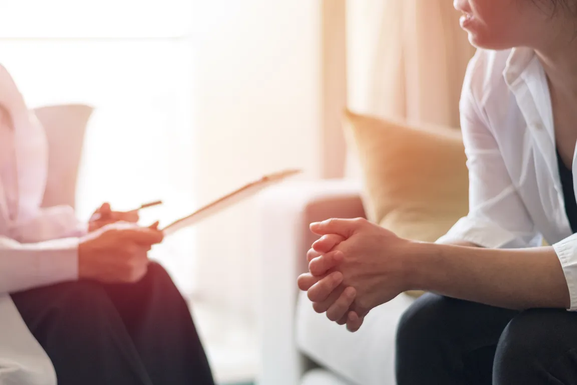 Doctor Talking with Patient Sitting on Opposite Couch