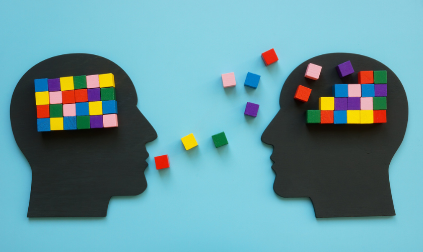 Graphic image representing two people talking and building knowledge via building blocks in head