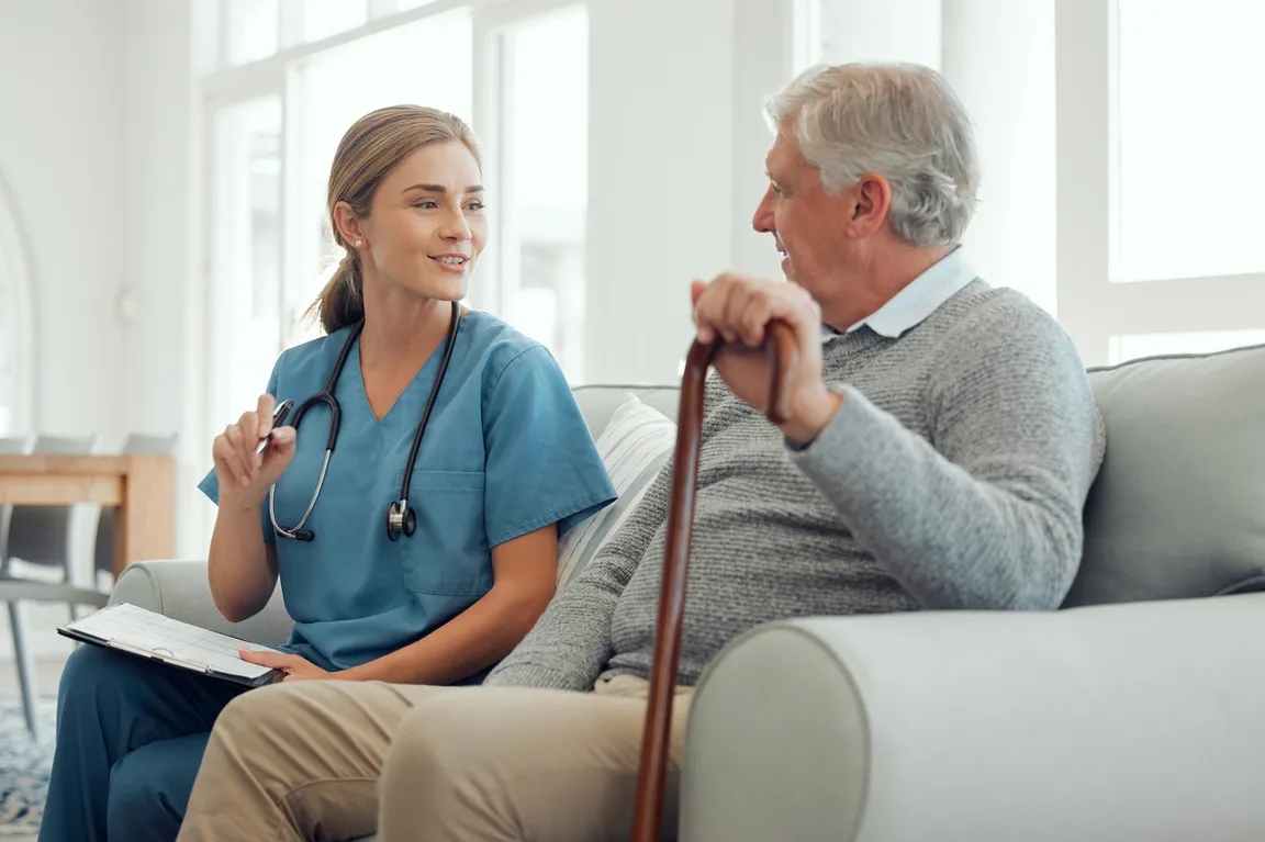 Health care worker and patient sitting on couch at home