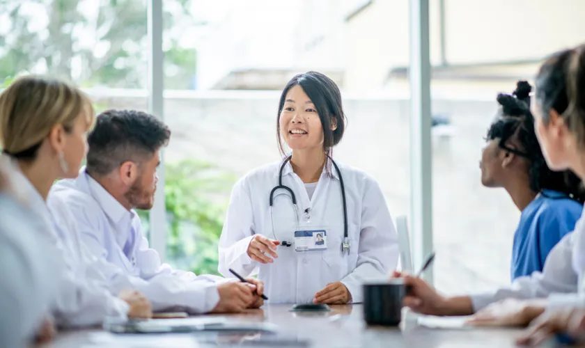 Medical students sit around a table engaged during a lecture_840x500