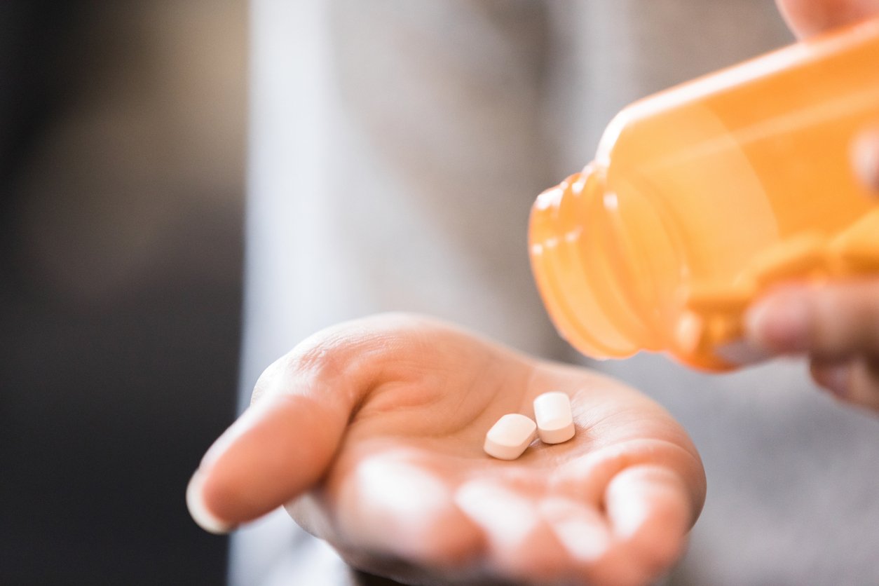 Person dispensing pills into hand