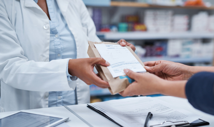 Pharmacist handing patient medication