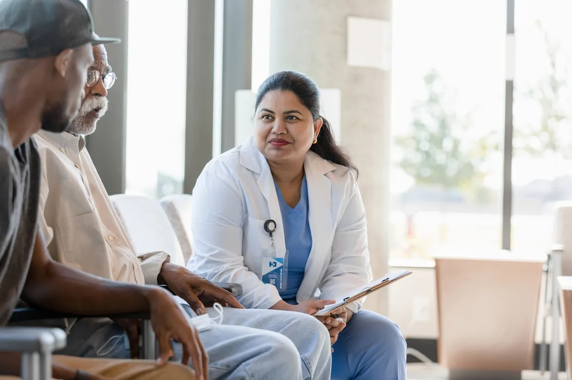 Photo of a clinician sitting and talking with a patient and caregiver - Flipped