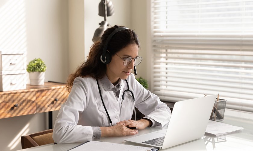 Professional female doctor wearing headphones consulting patient