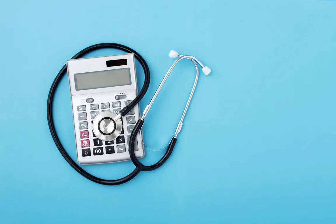 Stethescope and calculator on a blue background