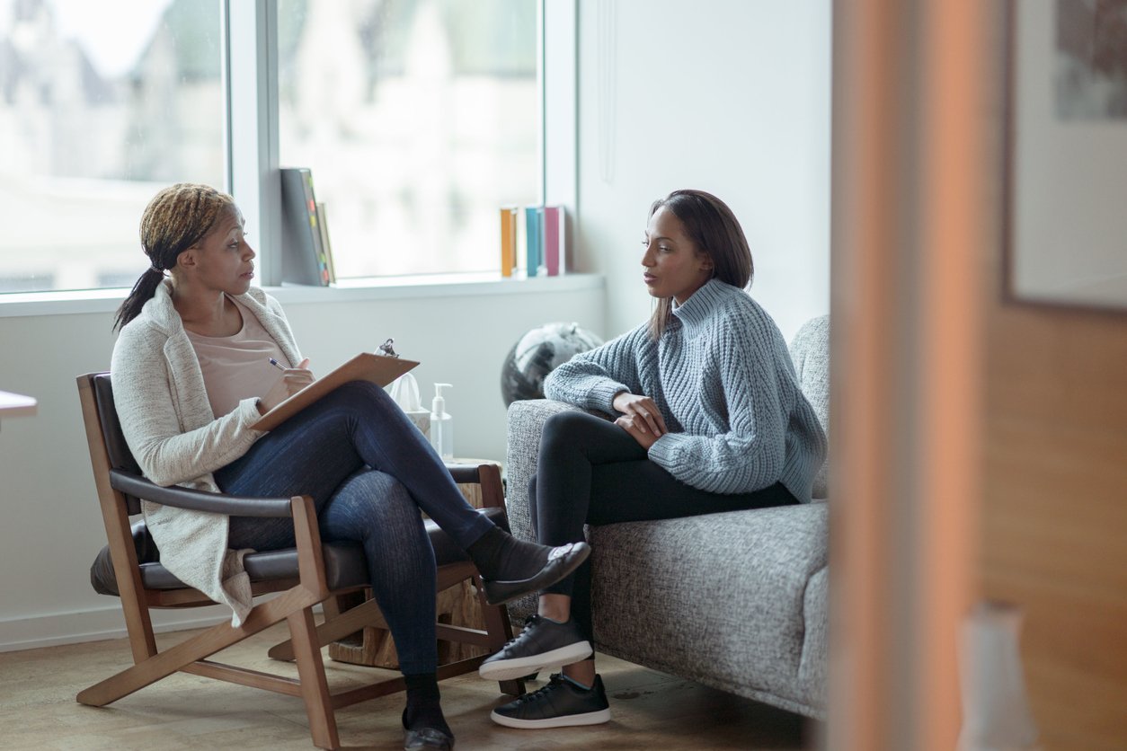 Therapist and client talking through trauma during therapy session