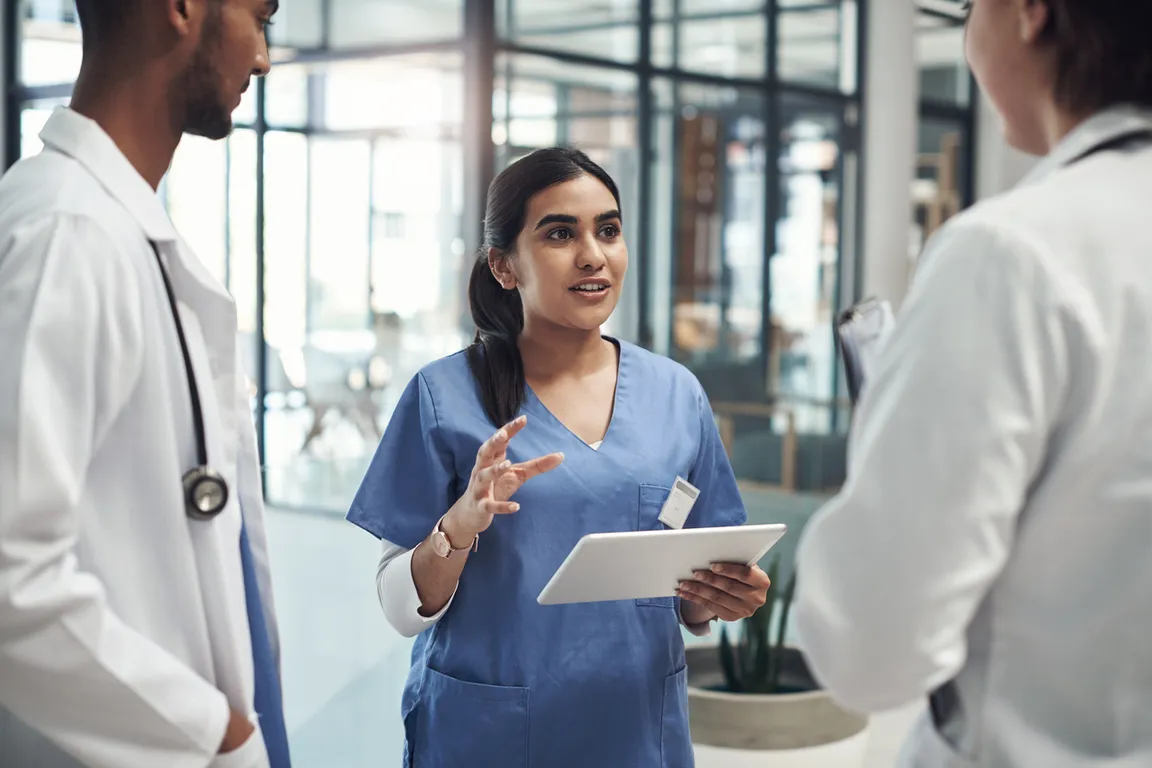 Three clinicians talking to each other in the hallway