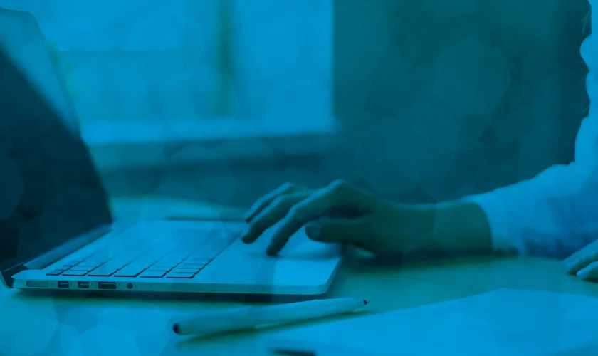 Person Sitting at Laptop Using Trackpad, Tinted Blue